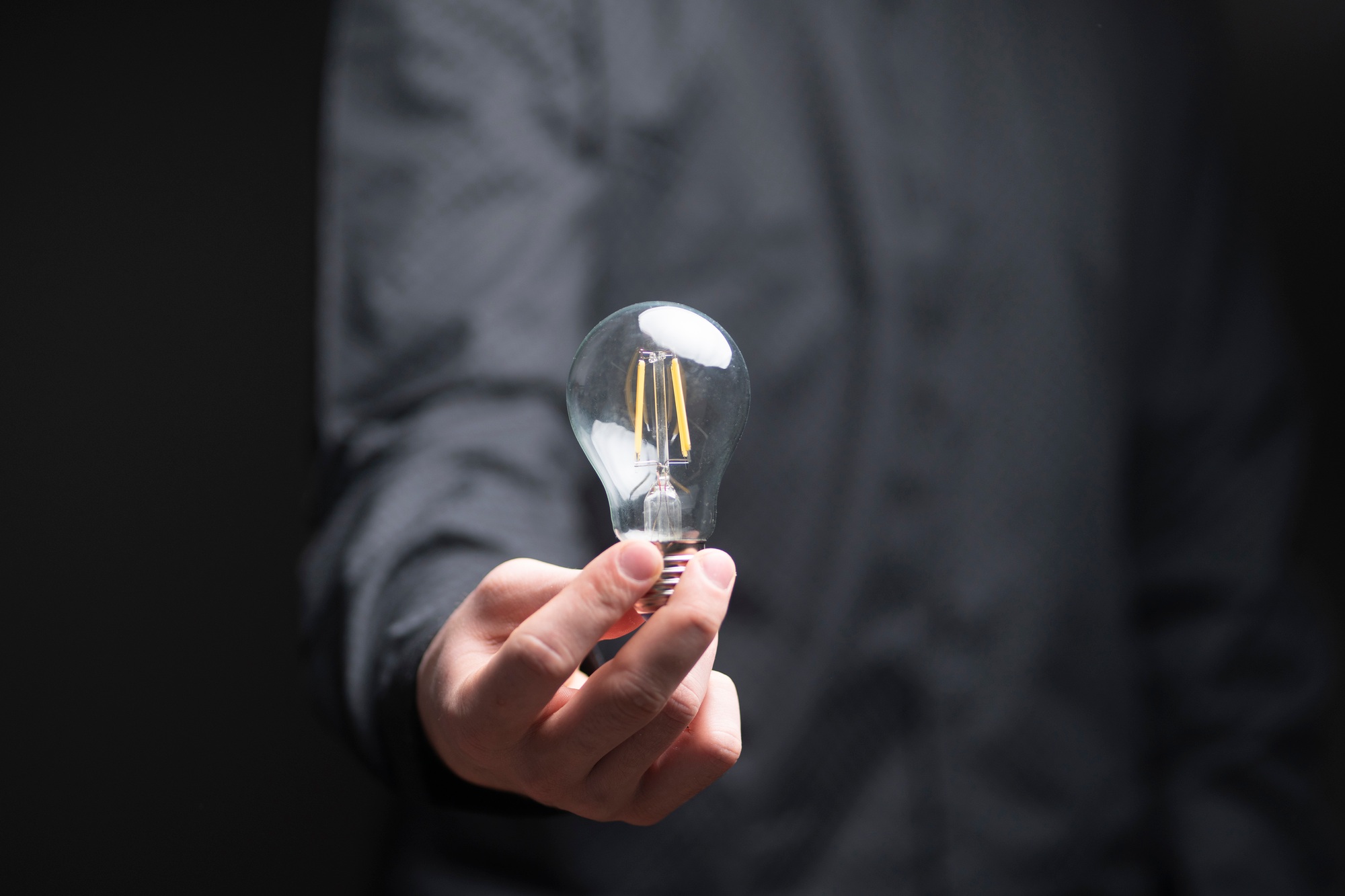 a businessman holds a light bulb as the symbol of new idea or solution